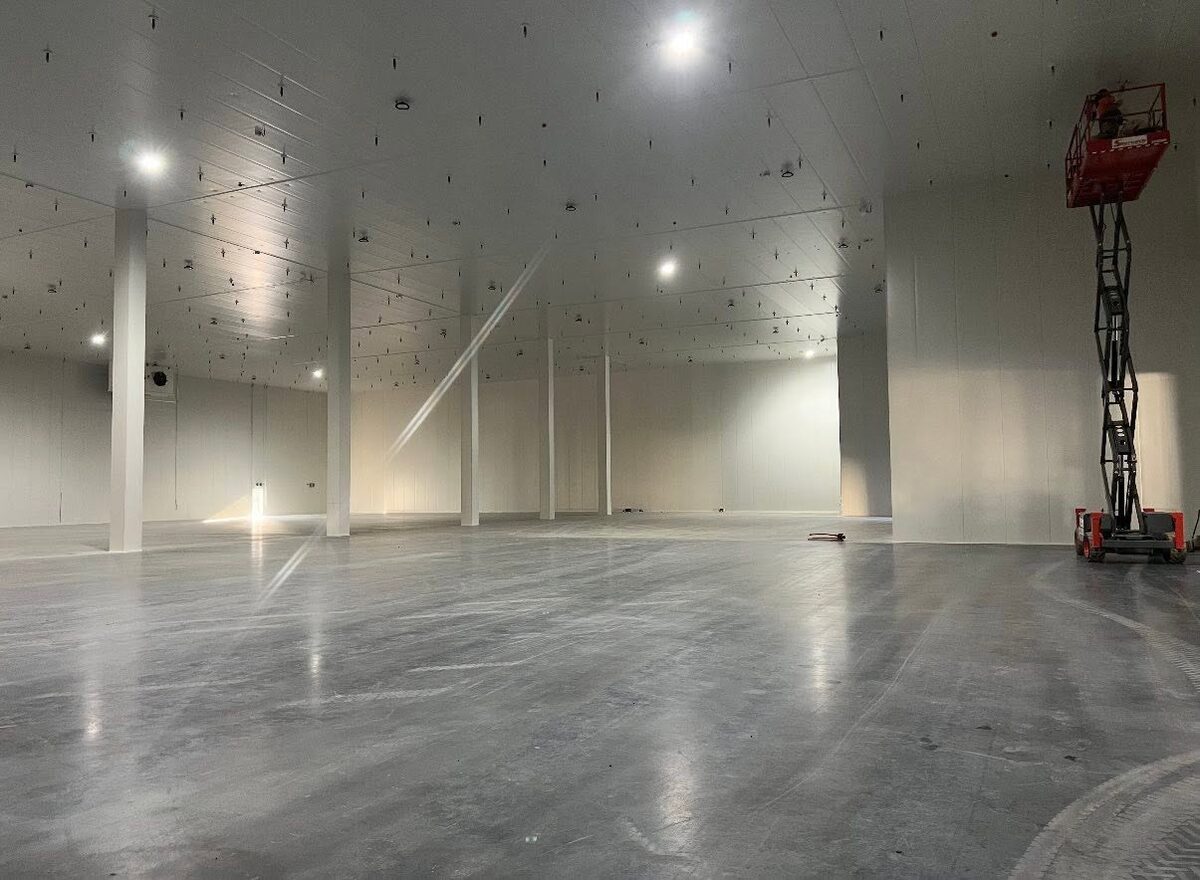 A commercial coolroom under construction, insulated panels going up with a scissor lift on site