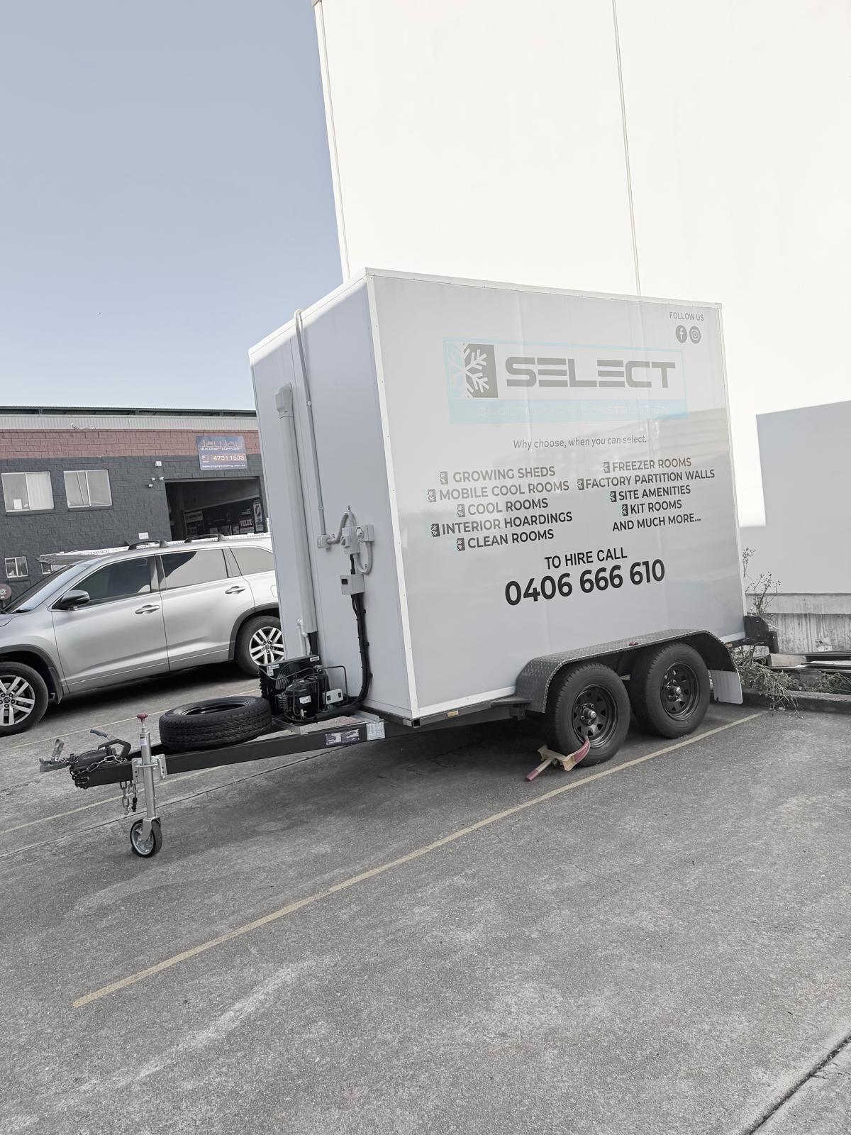 The trailer's tow hitch, coupling and jockey wheel, with the tandem axle and mounted refrigeration unit behind